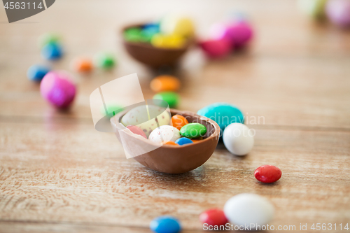 Image of chocolate easter egg and candy drops on table