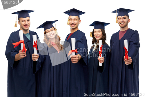 Image of graduates in mortar boards with diplomas