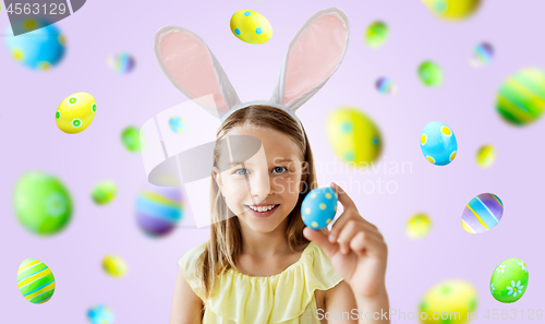 Image of happy girl with colored easter egg over violet