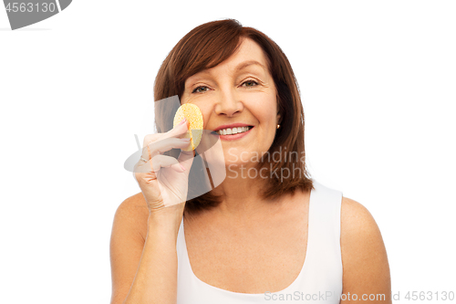 Image of woman cleaning face with exfoliating sponge