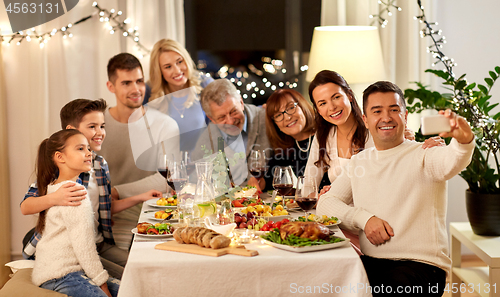 Image of family having dinner party and taking selfie