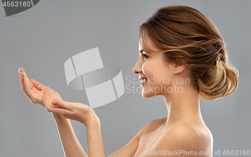 Image of smiling young woman holding something imaginary