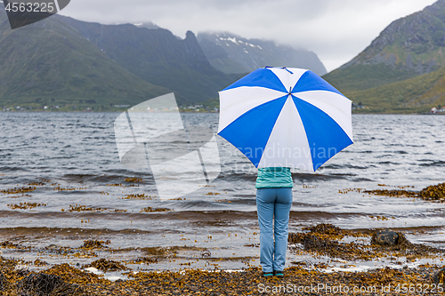 Image of Woman under an umbrella in the background of nature Norway