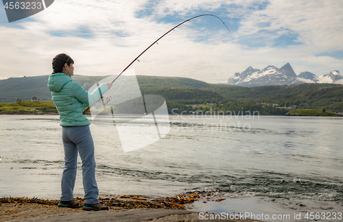 Image of Woman fishing on Fishing rod spinning in Norway.