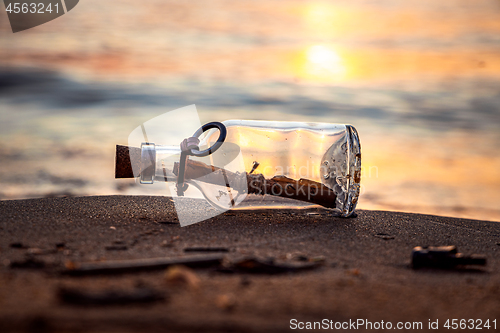 Image of Message in the bottle against the Sun setting down