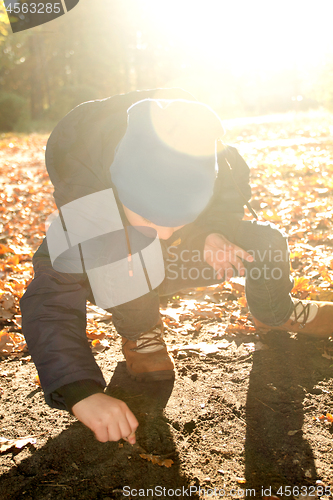 Image of Boy is writing something on the ground