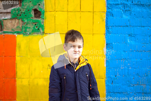 Image of Funny boy against color brick wall