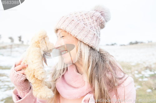 Image of Smiling woman nose to nose with teddy bear