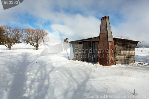 Image of Rustic log shed or stable in rural countryside with full coverag