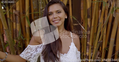 Image of Beautiful woman standing among bamboo trees