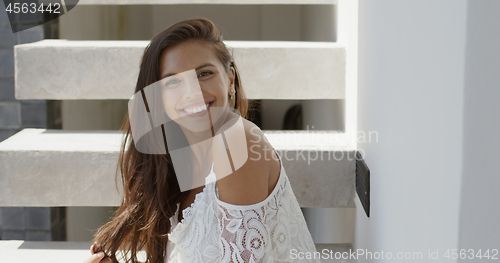 Image of Happy beautiful woman sitting on stairs