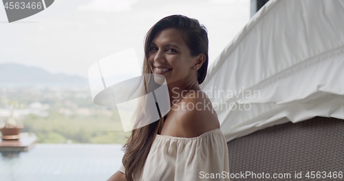 Image of Adult contented woman on terrace at resort