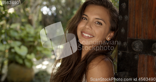 Image of Relaxed woman leaning on wooden door