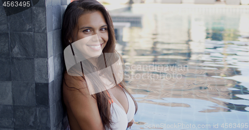 Image of Pretty cheerful woman relaxing at poolside