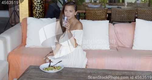 Image of Pretty woman having lunch and drinking water