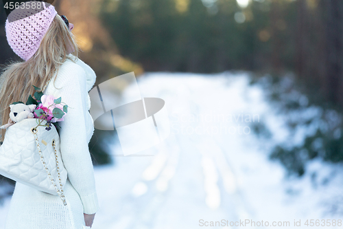 Image of Woman on a snow covered road in the forest