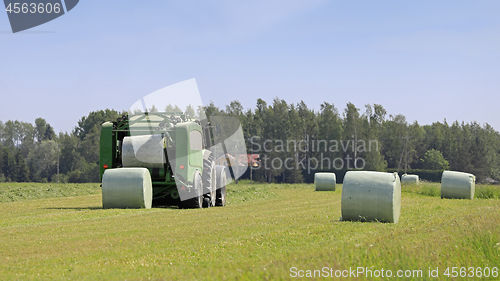 Image of Baler Wrapper Baling Silage in Field