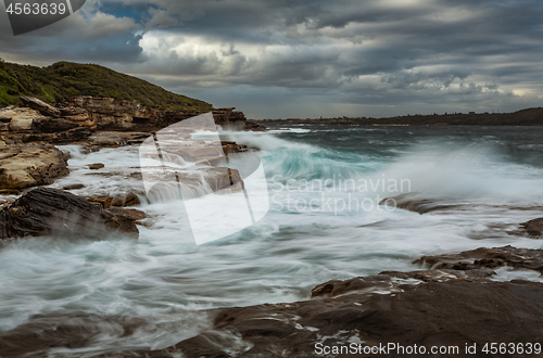 Image of Wave action on coastal rocks with waterfall cascades