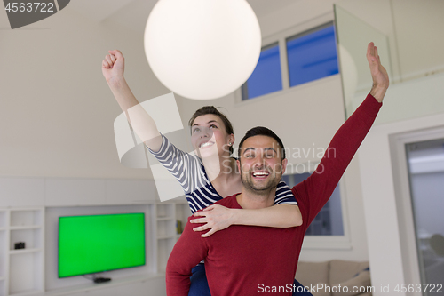 Image of handsome man piggybacking his girlfriend