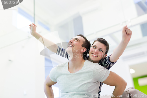 Image of handsome man piggybacking his girlfriend