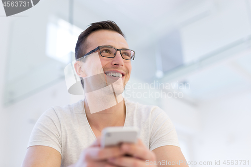 Image of young man using a mobile phone  at home