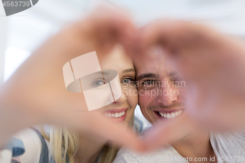 Image of couple making heart with hands