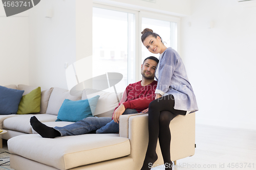 Image of couple hugging and relaxing on sofa