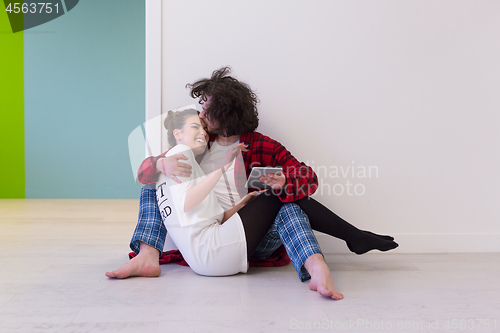 Image of Young Couple using digital tablet on the floor