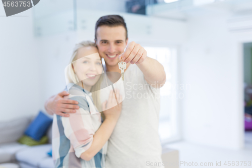 Image of couple showing a keys of their new house