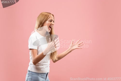 Image of The young emotional angry woman screaming on studio background