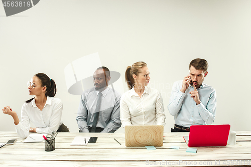 Image of Young men and women sitting at office and working on laptops. Emotions concept