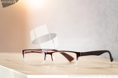 Image of reading glasses on a wooden table