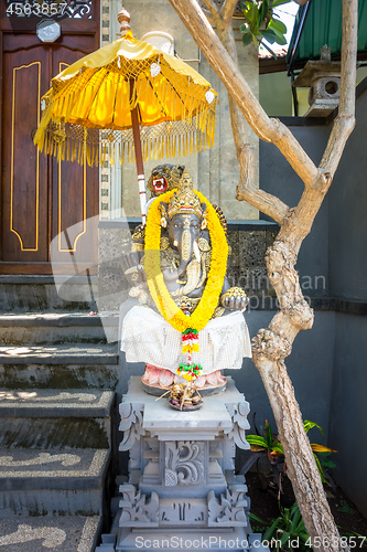 Image of Garland of golden flowers draped around Ganesha