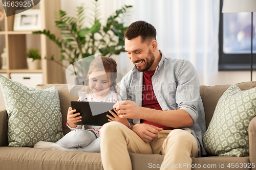 Image of father and daughter with tablet computer at home