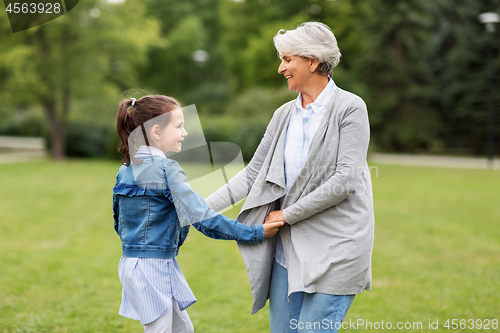 Image of grandmother and granddaughter playing at park