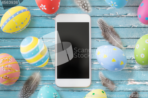 Image of smartphone with easter eggs and quail feathers