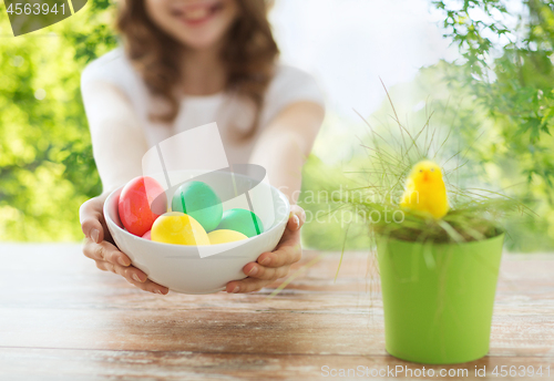 Image of close up of girl with bowl of colored easter eggs