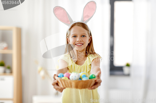 Image of happy girl with colored easter eggs at home