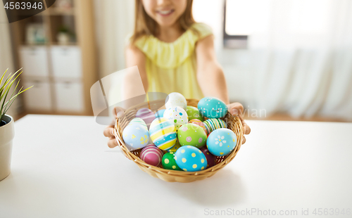 Image of close up of girl with easter eggs in wicker basket