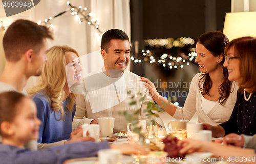 Image of happy family having tea party at home