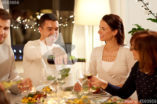 Image of happy family having dinner party at home