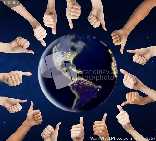 Image of human hands showing thumbs up around earth planet