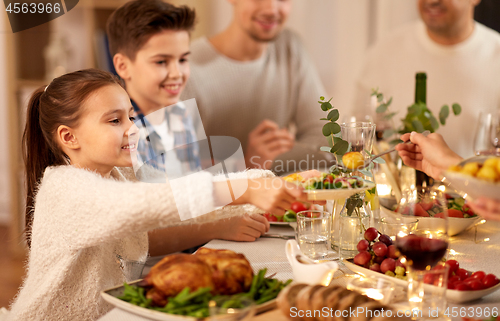 Image of happy family having dinner party at home