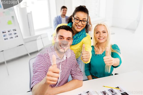 Image of creative team showing thumbs up at office