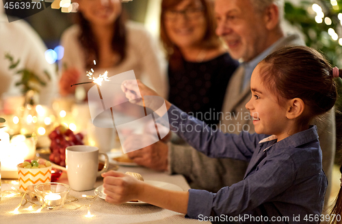 Image of happy girl with sparkler at family tea party