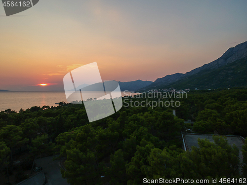 Image of An aerial view from drone to the trees and sunset over sea