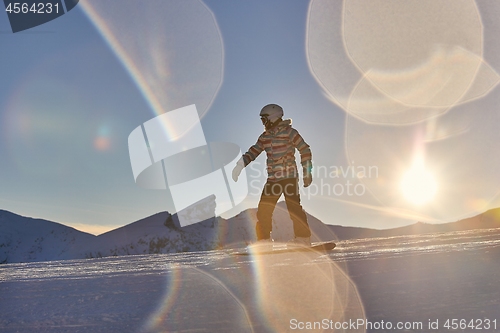 Image of Snowboarder in sun flare, water drops on lens