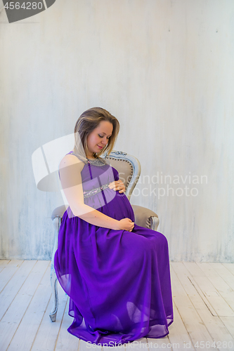 Image of Beautiful pregnant woman sitting