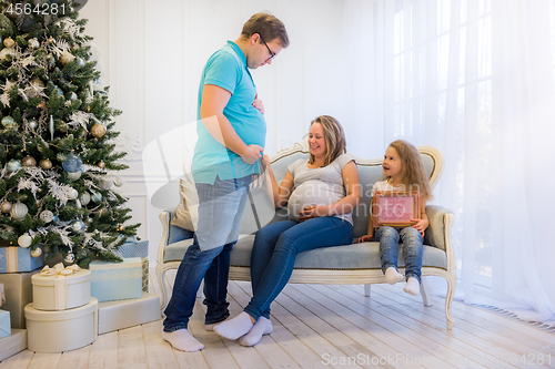 Image of Beautiful pregnant woman sitting with doughter and husband