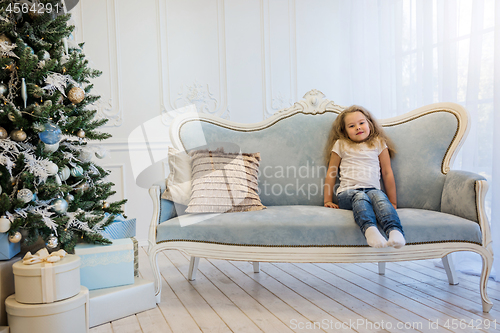 Image of Beautiful girl sitting on the sofa near